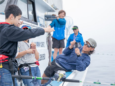 釣れた魚と一緒に写真を撮る男の子